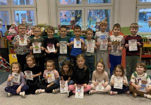 Dzieci z grupy „Motylki” pozują do zdjęcia ze swoimi pracami plastycznymi przedstawiającymi misia.