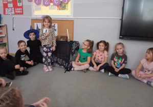 Zdjęcie przedstawia dziewczynkę z grupy Odkrywcy podczas losowania wróżby związanej z wyborem przyszłego zawodu.