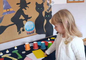 Dziewczynka losuje kopertę z wróżbą.