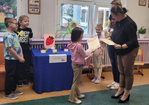 Dziewczynka odbiera nagrodę.