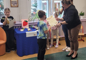 Chłopiec odbiera nagrodę.