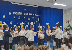 Dzieci tańczą w parach taniec ludowy pt. ,,Grozik”.