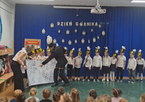 Dzieci z grupy Motylki wspólnie z panem górnikiem rozwijały wielką kolorowankę z obrazkami związanymi z kopalnią.