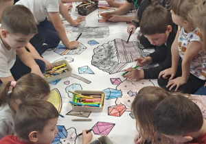 Wszystkie 6- latki z naszego przedszkola wspólnie malują kolorowankę od pana górnika na holu przedszkolnym.