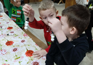 Dzieci z grupy Misie dumnie prezentują swoje bałwankowe ozdoby choinkowe.