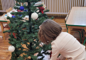 Dzieci z grupy Słoneczka pozują do wspólnej fotografii na tle choinki.