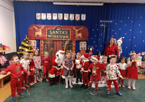 Dzieci z grupy stokrotki pozują do zdjęcia z Mikołajem