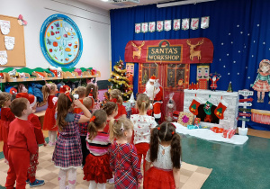 Dzieci stoją przed Mikołajem