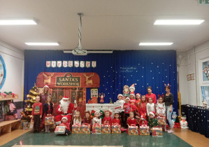 Na zdjęciu widzimy dzieci z grupy Odkrywcy pozujących z prezentami podarowanymi przez Świętego Mikołaja.