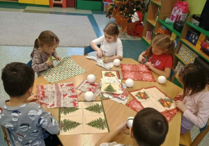 Dzieci ozdabiają bombki styropianowe.