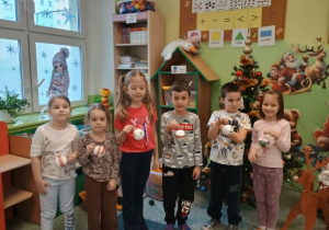 Dzieci pozują do zdjęcia ze swoimi bombkami.