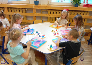 Na zdjęciu widzimy dzieci podczas wykonywania kolorowego podkładu.