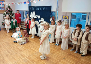 Zdjęcie przedstawia dzieci i jedno z dzieci przebrane za aniołka mówiące swoją kwestię.