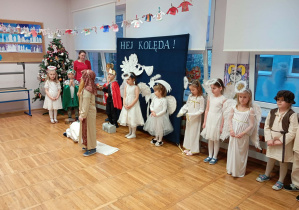 Zdjęcie przedstawia dzieci i jedno z dzieci przebrane za aniołka mówiące swoją kwestię.