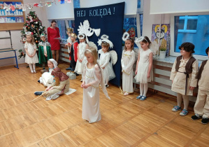 Zdjęcie przedstawia dzieci i jedno z dzieci przebrane za aniołka mówiące swoją kwestię.