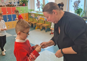 Chłopiec dzieli się z panią opłatkiem.