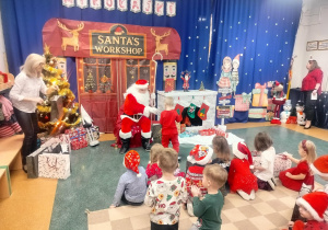 Dzieci siedzą na dywanie.