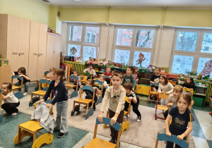 Dzieci uczą się matematyki poprzez zabawe z krzesełkami.