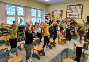 Dzieci uczą się matematyki poprzez zabawe z krzesełkami.