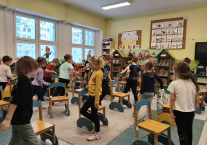 Dzieci uczą się matematyki poprzez zabawe z krzesełkami.