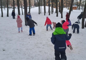 Dzieci biegają po śniegu.