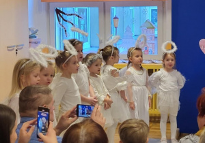 Dziewczynki z grupy Żabki podczas prezentowania koncertu życzeń dla babci i dziadka.