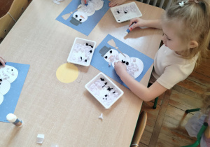 Dziewczynki wykonują pracę plastyczną.