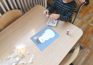 Chłopiec wykonuje pracę plastyczną.