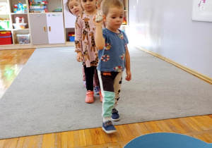 Chłopiec rzuca papierową kulą do kosza.