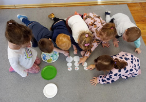 Dzieci układają bałwanki z kół różnej wielkości.