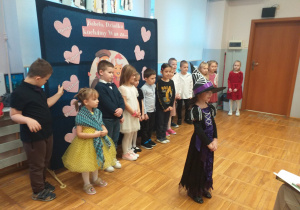 Zdjęcie przedstawia dziecko recytujące wierszyk.