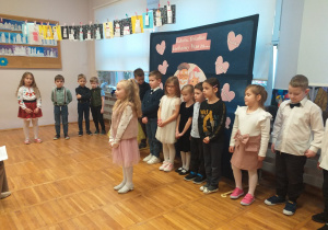 Zdjęcie przedstawia dziecko recytujące wierszyk.