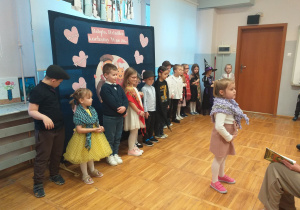 Zdjęcie przedstawia dziecko recytujące wierszyk.