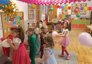 Dzieci w strojach karnawałowych podczas zabawy z balonami