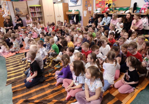 Na zdjęciu są dzieci siedzące na kocach czekające na rozpoczęcie audycji muzycznej.