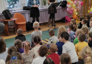 Dwie młode kobiety śpiewają dzieciom głosem operowym.