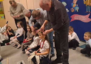 Dziadkowie biorą udział w konkursie, czeszą swoje wnuczki.