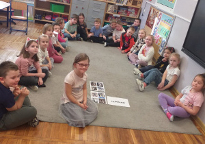 Zdjęcie przedstawia dzieci z grupy Odkrywcy pozujące do zdjęcia z ilustracjami pingwinów.