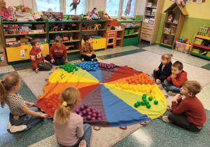 Dzieci segregują kolory na chuście animacyjnej.