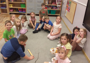 Zdjęcie przedstawia dziecko mierzące jeden z patyków.