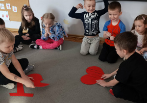 Koledzy z grupy „Misie” układają puzzlowe serduszka.