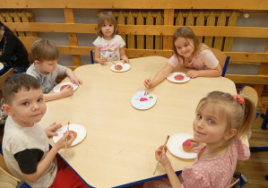 Dzieci z grupy Odkrywcy dekorują pączki wykonane z masy solnej.