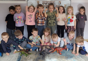 Wspólna fotografia wraz z figurkami dinozaurów.