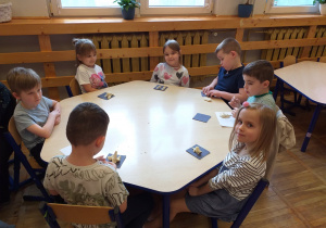 Zdjęcie przedstawia dzieci z własnoręcznie ulepionymi dinozaurami własnego pomysłu z masy solnej.