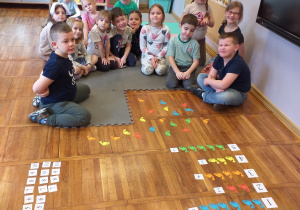 Zdjęcie przedstawia dzieci przed dokładaniem kolejnych dinozaurów.