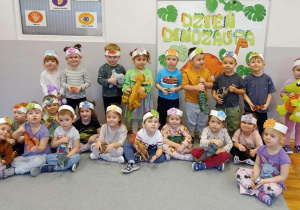 Zdjęci grupowe - dzieci prezentują przyniesione z domu dinozaury.