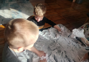 Dzieci bawią się piaskiem kinetycznym.