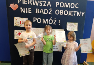 Dzieci pozują do zdjęcia z dyplomami i upominkami.