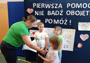 Pani wicedyrektor wręcza dyplom dziewczynce