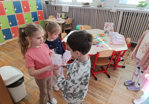Chłopiec z grupy „Misie” wręcza prezent koleżance.